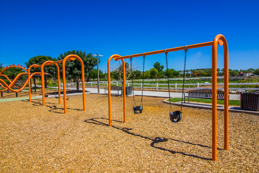 A swing set in a playground on a sunny day